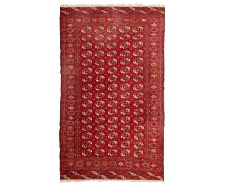 TEKKE CARPET  TURKMENISTAN, LATE 20TH CENTURY   the red field with five columns of sixteen guls, within red starburst border,