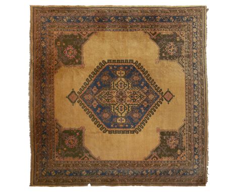 USHAK CARPET  WEST ANATOLIA, EARLY 20TH CENTURY   the plain camel field with indigo and camel medallion, bottle green spandre