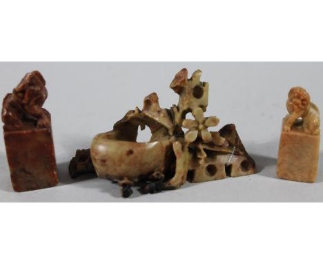 Three various Chinese soapstone ornaments, comprising a desk seal with dragon head in red, 6cm high, another similar, predomi
