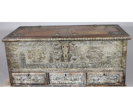 An early 19thC Kuwait travelling mule chest, the rectangular overhanging top and front profusely decorated with a floral stud