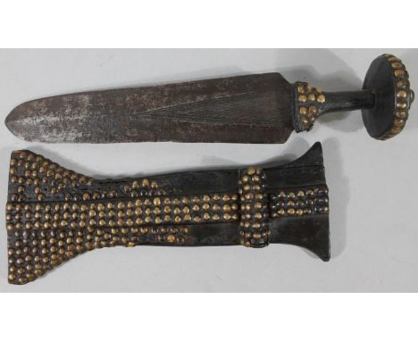 An African tribal dagger, the highly elaborate studded shaped scabbard revealing a part textured geometric pattern metal blad