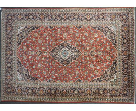 A Persian red ground carpet, 385cm x 265cm