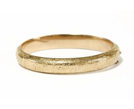 A 9ct gold hinge bangle, with engraved decoration to top section and initials to plain section11.11g