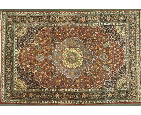 A hand knotted Persian carpet, the red and blue fields with central floral medallion within a triple border, 380 x 80cm