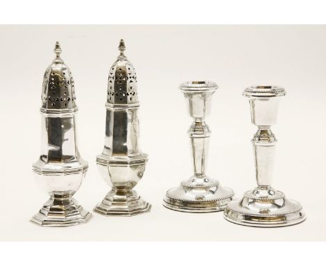 A pair of silver sugar casters, and a pair of silver candlesticks