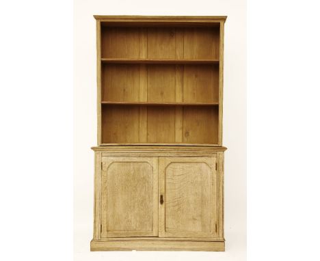 A limed oak bookcase, with open shelf top over a pair of cupboard doors, 121 x 37 x 199cm high