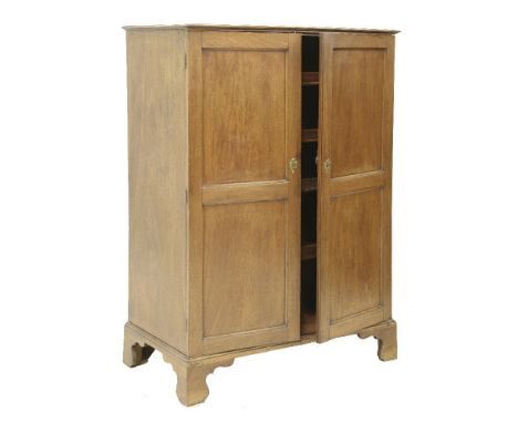 A George III mahogany press cupboard, the two panelled doors enclosing four slides,96cm wide, 54.5cm deep, 137cm high