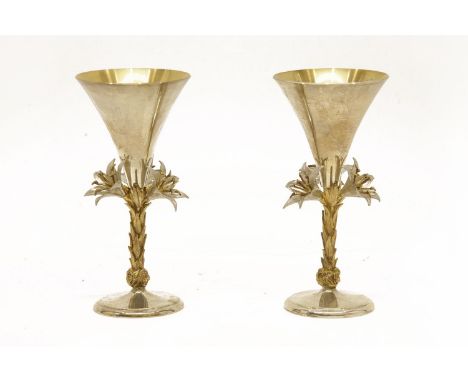 A pair of Elizabeth II silver goblets, each with a conical bowl and flower encrusted stem, commemorating the fifth anniversar