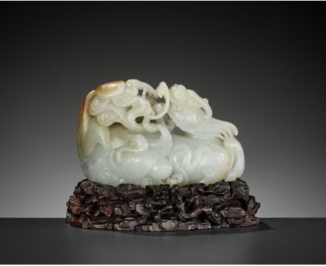 A CELADON AND RUSSET JADE 'QILIN AND CRANES' GROUP, 18TH CENTURYChina. Carved as a recumbent qilin, the legs tucked underneat