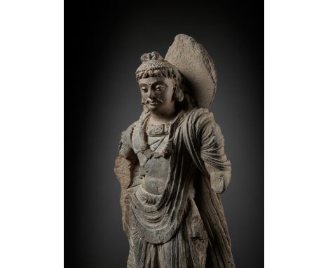 A SCHIST FIGURE OF MAITREYA, ANCIENT REGION OF GANDHARAKushan period, 2nd-3rd century. Dressed in a finely pleated robe drape