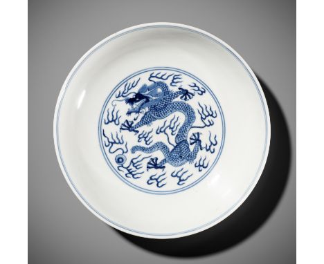 A BLUE AND WHITE 'DRAGON' DISH, JIAQING MARK AND PERIODChina, 1796-1820. The shallow rounded sides rising from a short tapere