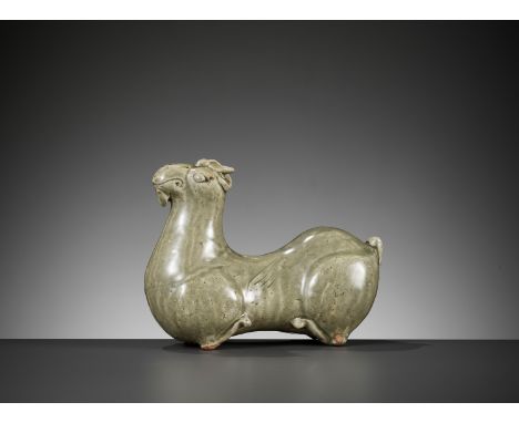 A YUE CELADON-GLAZED FIGURE OF A RAM, WESTERN JIN DYNASTYChina, 265-317. The recumbent animal resting upon its tucked-in hind