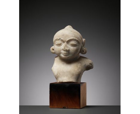 A JAIN WHITE MARBLE BUST OF THE CHILD KRISHNA, 14TH-15TH CENTURYIndia, Rajasthan. Well carved, the face with large almond-sha