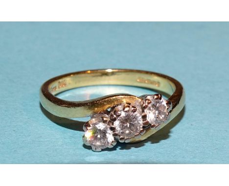 A three stone diamond ring,&nbsp;claw set brilliant cut diamonds, total approx 0.5cts i 18ct gold cross-over mount, L, 3.7g. 