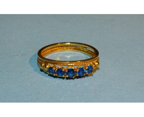 A yellow gold ring set blue stones, marked '18', size L, 2.4g. 