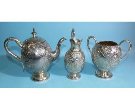 A Victorian silver teapot of ovoid form with all-over decoration of flowers and scrolls, on circular foot, maker RH, London 1