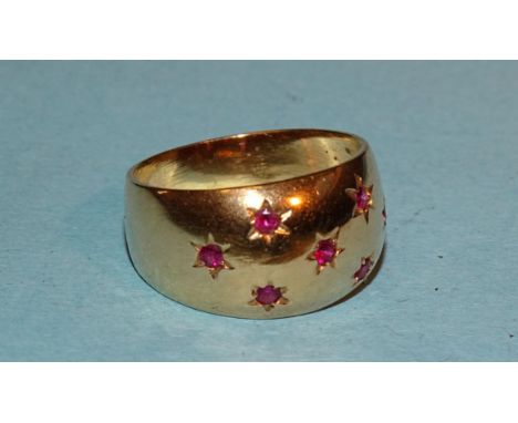 A gold ring set seven small round-cut rubies, marked '750', M,&nbsp; 5.5g.