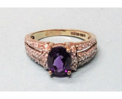 A 9ct gold ring set an amethyst between diamond point-set shoulders, (boxed). 