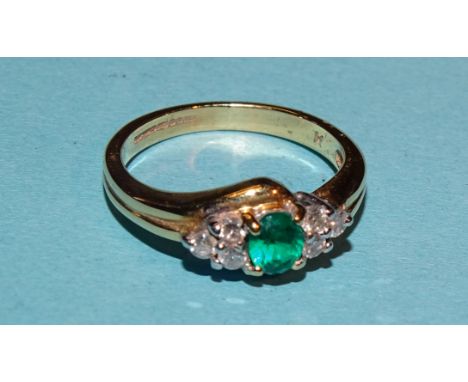 An 18ct gold ring set a round-cut emerald between triplets of brilliant-cut diamonds, size M, 4.1g. 