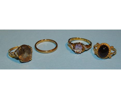 A 9ct gold ring set smoky quartz, size M½, an amethyst-set 9ct gold ring, size N, a smoky quartz 9ct gold ring and a 9ct gold