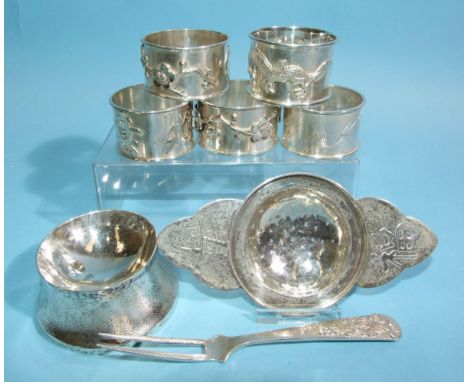 A Chinese silver two-handled tea strainer, 13.5cm wide, and stand, a pair of Chinese silver napkin rings decorated with prunu