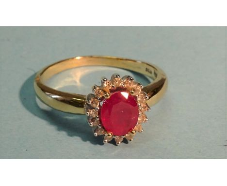 A ruby and diamond cluster ring claw-set an oval ruby within a surround of sixteen diamond points, in 18ct yellow and white g