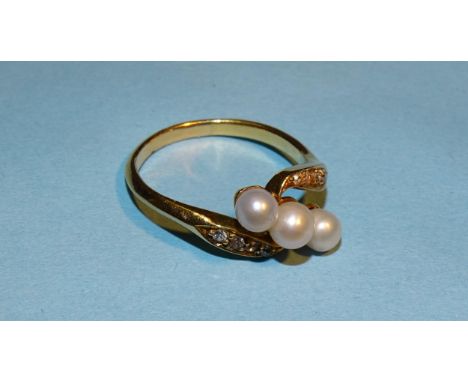 A gold cross-over ring set three cultured pearls between 8/8-cut diamond-set shoulders, unmarked, tested as 18ct gold approxi