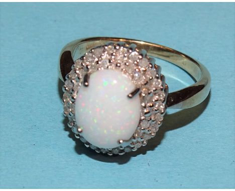 An opal and diamond cluster ring claw-set an oval opal within two rows of 8/8-cut diamond points, in 9ct yellow and white gol