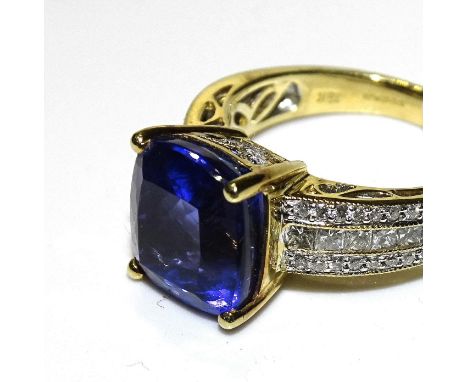 &nbsp;A Tanzanite and diamond ring, claw set a cushion cut Tanzanite of approx 8cts between shoulders set three lines of squa