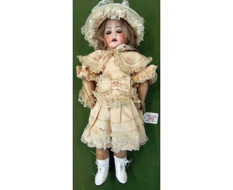 A MAX HANDWERCK BISQUE SOCKET HEAD DOLL  with a blonde wig, sleeping brown glass eyes, and an open mouth with four upper teet