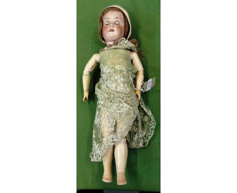 A BISQUE SOCKET HEAD DOLL  probably German, with a light brown wig, sleeping brown glass eyes, and an open mouth with four up