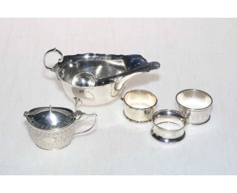 Silver sauce boat with silver serving spoon, silver lidded mustard pot, and three silver napkin rings (6).