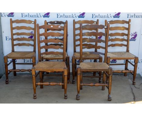 A set of six Rush seated Ladder back dining chairs raised on turned supports joined by stretchers.