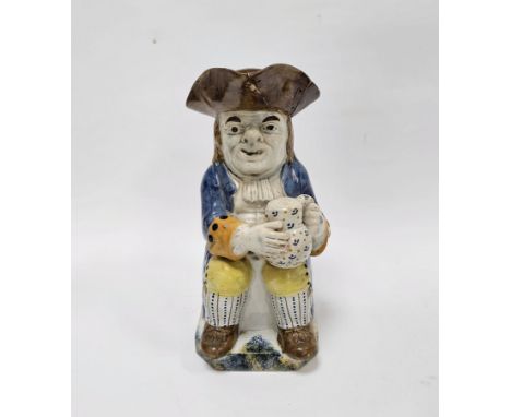 English Prattware Toby jug and cover, circa 1820, modelled seated holding a jug of foaming ale wearing a black tricorn hat, a