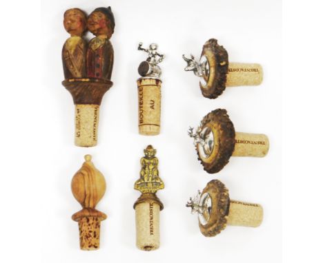 Seven novelty cork bottle stoppers including silver topped stopper in the form of a Bacchus on a barrel, London 1975, set of 