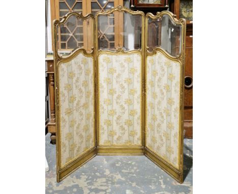 19th century French giltwood three-fold dressing screen, of rococo style shaped outline with foliate scroll carving, each sec