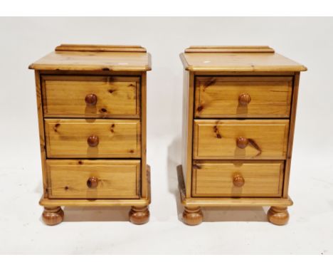 Pair of modern pine bedside chests of drawers, each with three drawers and pine knob handles, on ball feet, 69cm high x 45cm 