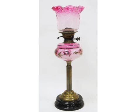 Victorian brass column oil lamp&nbsp;having a frilled pink tinted shade and opaque pink glass well decorated with flowers, on