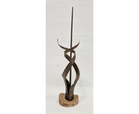 An abstract metal sculpture of spiral form surrounding central pillar, mounted on a wooden base, 65cm high