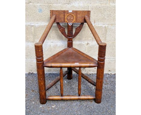 19th century oak turner's corner chair with carved back rail, bobbin carved arms, solid seat, on turned legs united by stretc