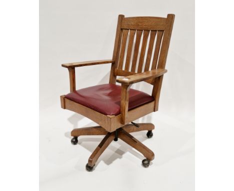 American Arts &amp; Crafts-style oak office swivel elbow chair&nbsp;by The Stickley Brothers, having a slat back and red leat