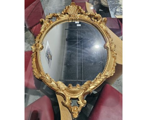 20th century gilt framed oval wall mirror,&nbsp;scrolling acanthus and shell border, approximately 101cm by 62cm
