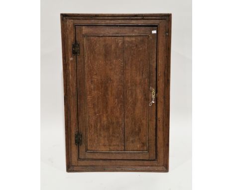 George III oak hanging corner cabinet, the single panel door opening to two fitted shelves (with key), 102cm high x 68cm wide