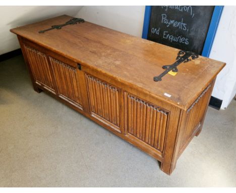 Large oak coffer in the 17th century manner, the lid with iron strapwork decoration, the front and sides with linenfold panel
