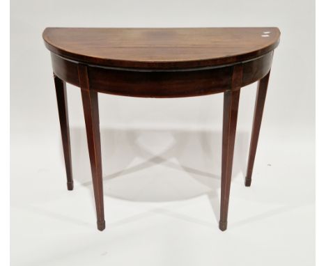 Mahogany and crossbanded demi-lune foldover card table in the Sheraton manner, the hinged top opening to a surface with the b