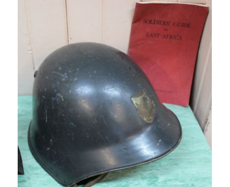 A Swiss 'model M18' helmet with a booklet 'Soldiers Guide to East Africa'