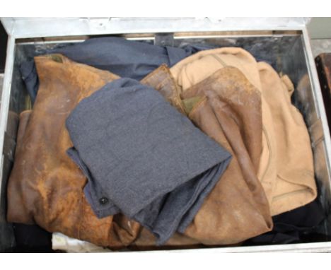 A tin trunk containing various uniforms including leather jerkins and a pair of 1944 dated W.A.A.F. trousers