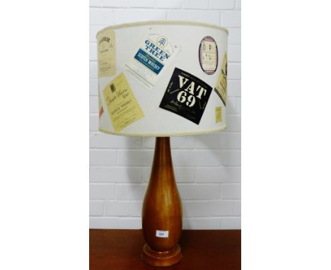 A teak table lamp, the shade with vintage spirit labels, height 70cm