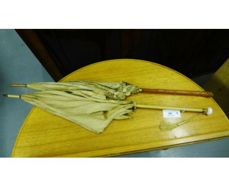 Two vintage parasols to include one with a ceramic finial and the other with a fruitwood handle (2) 