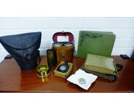 A selection of WWI memorabilia to include a crested ware trinket dish, a trench art vase and another, a gas mask, a compass, 